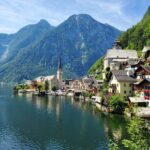 houses near body of water and mountain during daytime